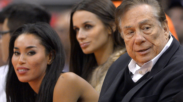 Los Angeles Clippers owner Donald Sterling, right, and V. Stiviano, left, watch the Clippers play the Sacramento Kings in October 2013.