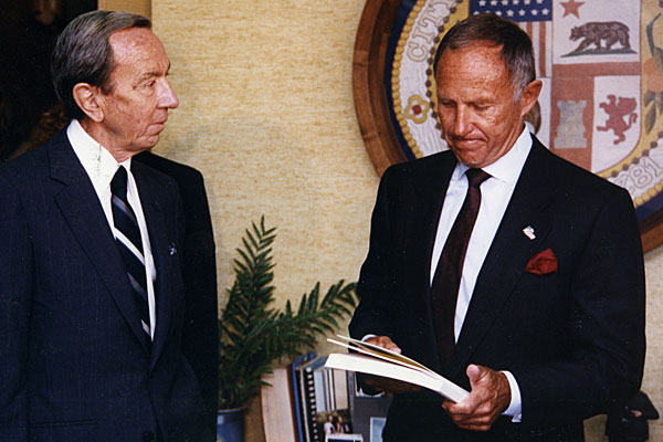 Warren Christopher gives Police Chief Daryl F. Gates a copy of the Christopher Commission report.