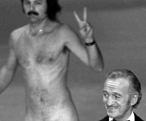 A man later identified as Robert Opel streaks behind host David Niven.