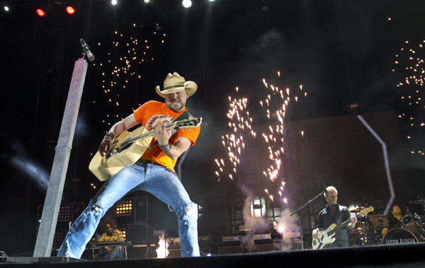 Jason Aldean performs onstage amid blasting pyrotechnics.