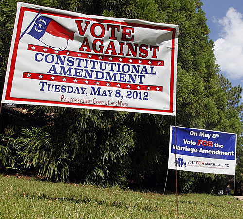 Signs in support of and against a constitutional amendment to ban same-sex marriage greet voters at a polling station in Raleigh, N.C.