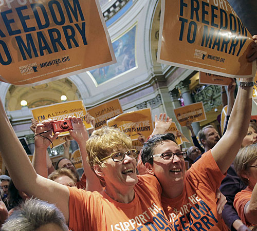 Cindy Amberger, left, and her partner, Lynne Hvidsten celebrate after the Minnesota House passed the gay marriage bill.