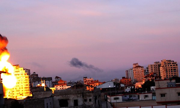 Flames erupt from a building after an Israeli strike in the center of Gaza City on Thursday.